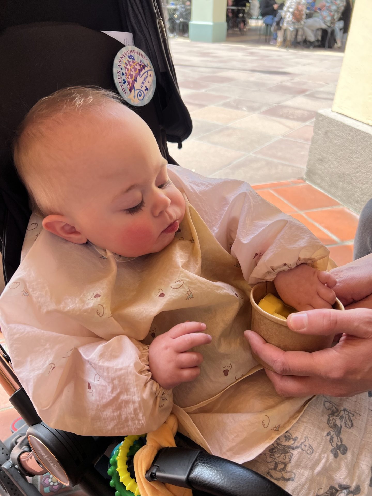My almost-one-year old eating her tub of mango at Disneyland Paris